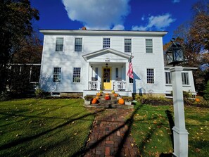 A white house with a front porch, a brick pathway, and a small lamp post. - The Buckmaster Inn (Shrewsbury)