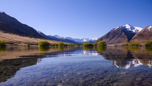 A clear lake reflecting mountains and trees. - The Lindis (Birchwood)