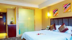 A hotel room with a large bed, a wooden headboard, and a wall-mounted TV. - Chengdu Yijin Hotel (Chengdu)
