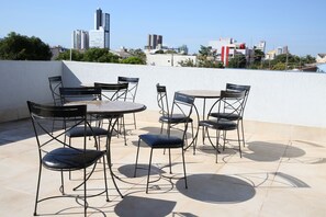 A rooftop terrace with outdoor seating and a cityscape view. - Hotel Araguaia (Palmas)