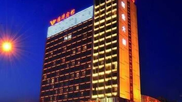 A multi-story hotel with a prominent sign at the top. - Lin Yi Hotel (Linyi)