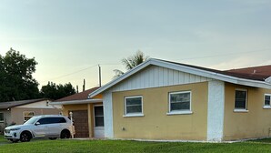 Ein Wohnhaus mit befestigter Auffahrt und Rasenfläche.