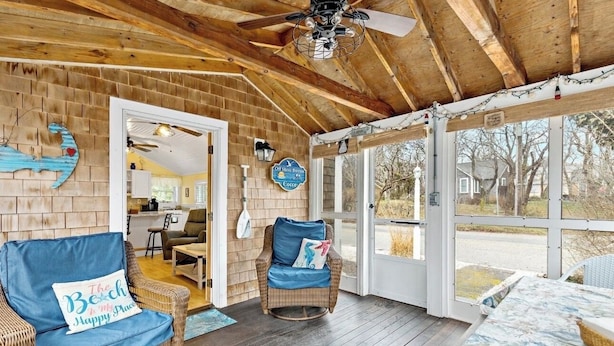 A covered porch with wicker furniture, a ceiling fan, and a view of the outside. - Steps To Bay at Campground Beach, A/C, Heat,Wifi, Outdoor Shower, Gas Grill (Eastham)
