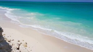 Ein Strand mit klarem türkisblauem Wasser und einem sandigen Ufer.