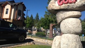 A stone sign with 'Magic Carpet Golf' written on it.