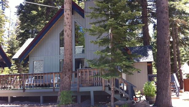 A two-story building with a wooden deck and stairs leading to the upper level.