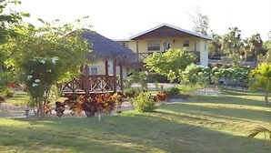 Una casa con tetto di paglia e un giardino recintato.