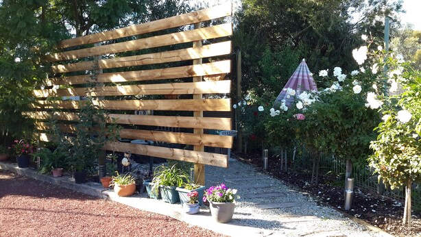 A wooden pergola with potted plants and flowers. - Barham Colonial Motel (Barham)