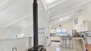 Cuina amb estufa negra, armaris blancs i una finestra.