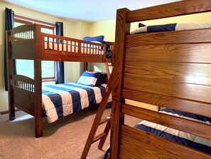 A bunk bed with a wooden frame, a window with curtains, and a carpeted floor. - Fantastic Vacation Rental in Lake Como, Sleeps 8-12 (Lake Geneva)