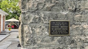 Un mur de pierre sur lequel est fixée une plaque indiquant que la propriété est inscrite au registre national des lieux historiques.