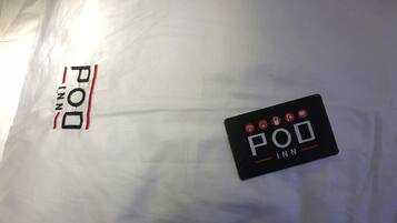 A black sign with the text "POU INN" and icons indicating amenities such as Wi-Fi, a bed, a bathroom, and a TV.