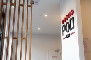 Una habitación con pared blanca, un separador de madera y una puerta con señal de seguridad contra incendios.