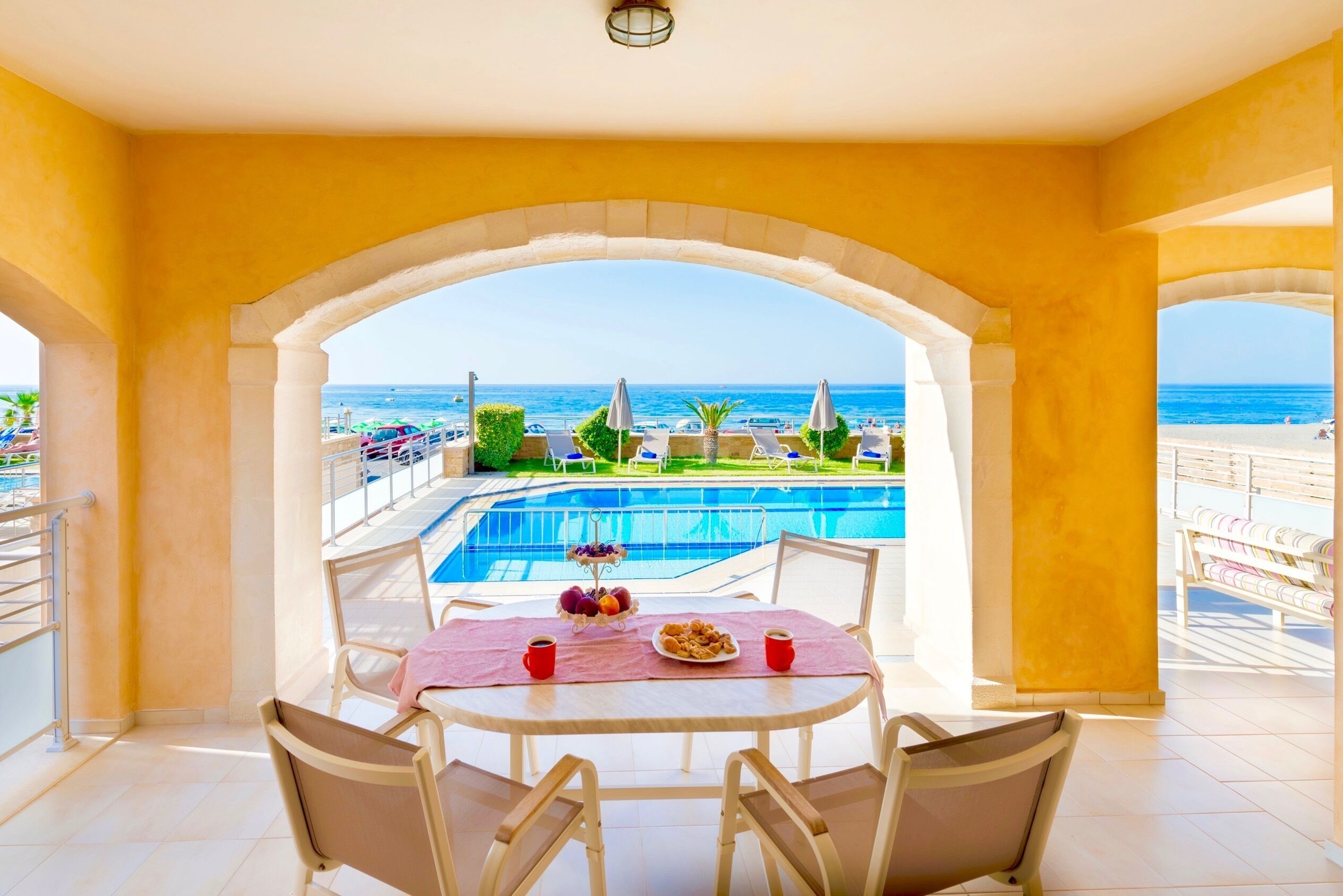 A dining area with a view of a pool and beach.