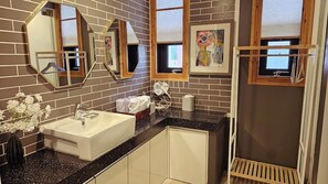 A bathroom with a white sink, black countertop, and multiple mirrors. - Gallery Family Hotel (Mokpo)