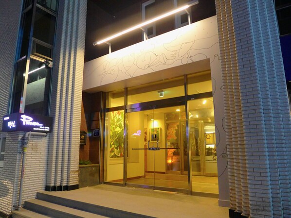 A hotel entrance with a glass door, a neon sign, and a brick facade. - Gallery Family Hotel (Mokpo)