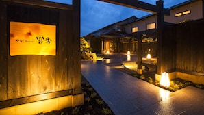 A wooden gate with a sign, a pathway, and buildings in the background. - Yusai Resort HIBIKI (Kyotango)