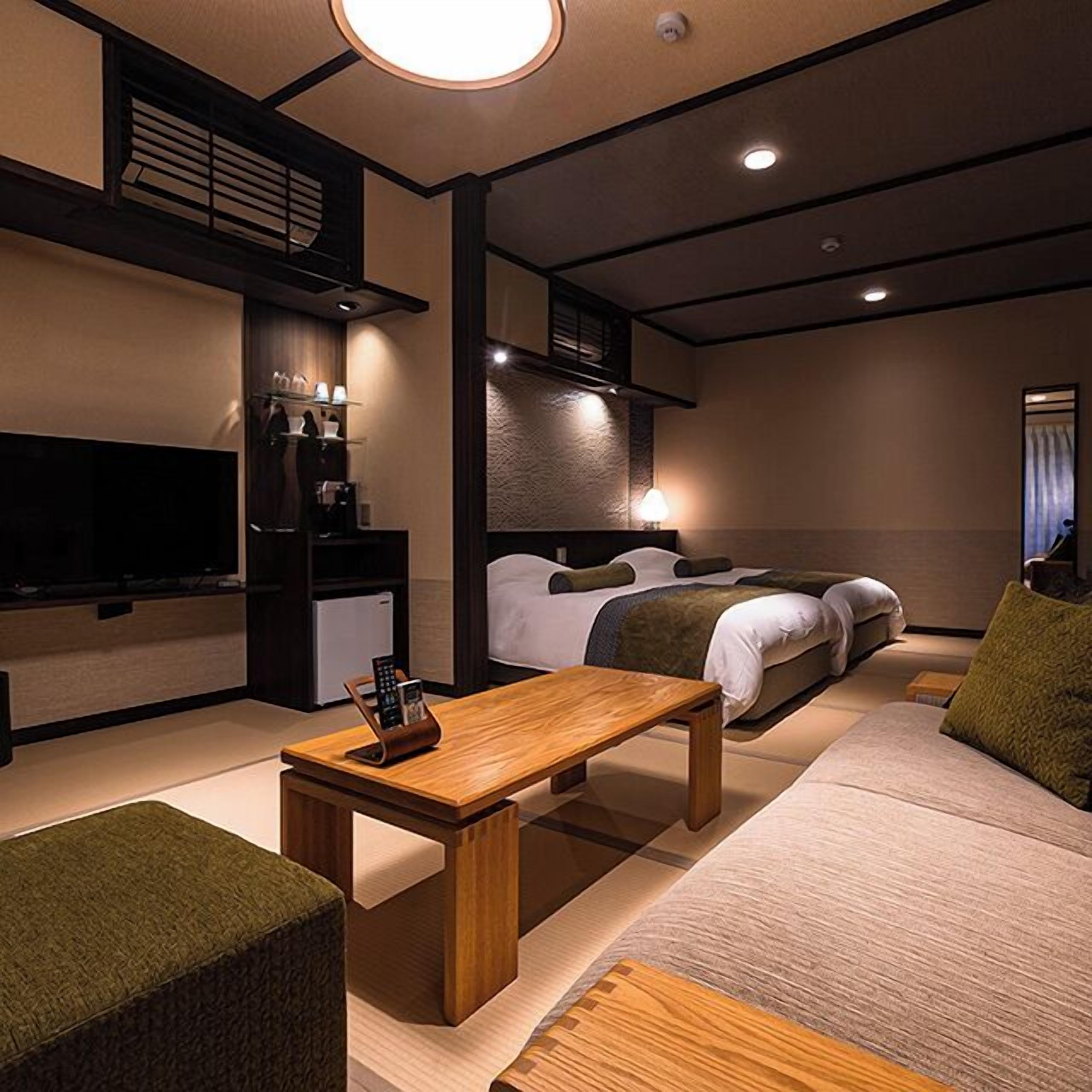 Une chambre d’hôtel moderne équipée d’un lit, d’un canapé, d’une table et d’un téléviseur.