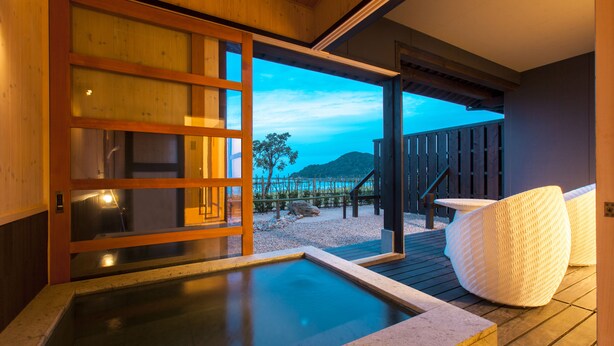 A hot spring area with a wooden deck and a view of a mountain. - Yusai Resort HIBIKI (Kyotango)
