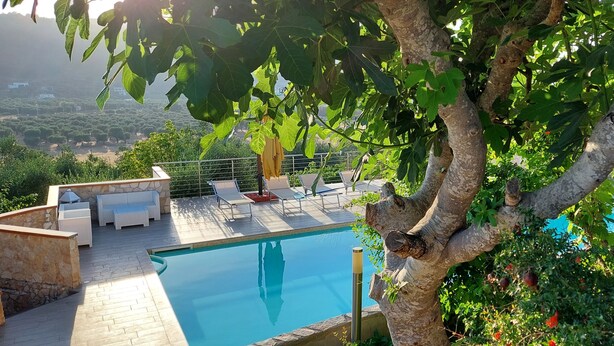 A poolside area with lounge chairs and a view of a landscaped garden. - Brand new apartment with veranda (Peschici)