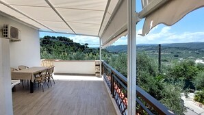 A balcony with a table and chairs, overlooking a scenic landscape. - Brand new apartment with veranda (Peschici)