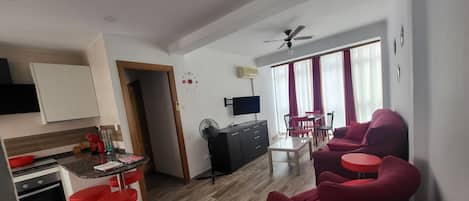 Un espacio moderno de estar con cocina, comedor y zona de descanso.