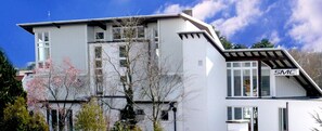 A two-story building with a white exterior and a sign reading "SMC" on the side. - SMC Münster - double room (Münster)