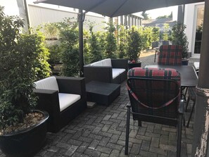 An outdoor patio area with wicker furniture, including sofas and chairs, and potted plants. - SMC Münster - double room (Münster)