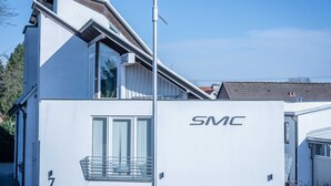 A modern building with a white exterior and the logo 'SMC' on the side. - SMC Münster - double room (Münster)