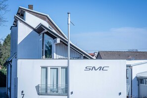 A modern building with a white exterior and the logo 'SMC' on the side. - SMC Münster - double room (Münster)