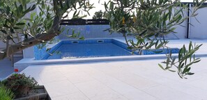 Una piscina con cubierta de baldosas y borde azul.