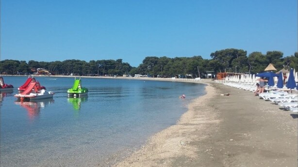 A beach with boats, umbrellas, and beach chairs. - Villa Mediteran Liznjan home with private pool in Istria
 (Ližnjan)