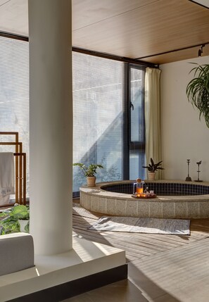 A modern bathroom with a freestanding bathtub, a potted plant, and a towel rack. - Vangen Spa Hotel (Miyun)