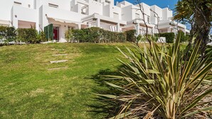 A modern white building with a well-maintained lawn and a red door.