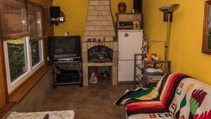 Una sala de estar acogedora en el ático con chimenea, televisor y sofá.
