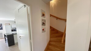 Eine Treppe mit Holzboden und Geländer, die zu einer oberen Etage führt.