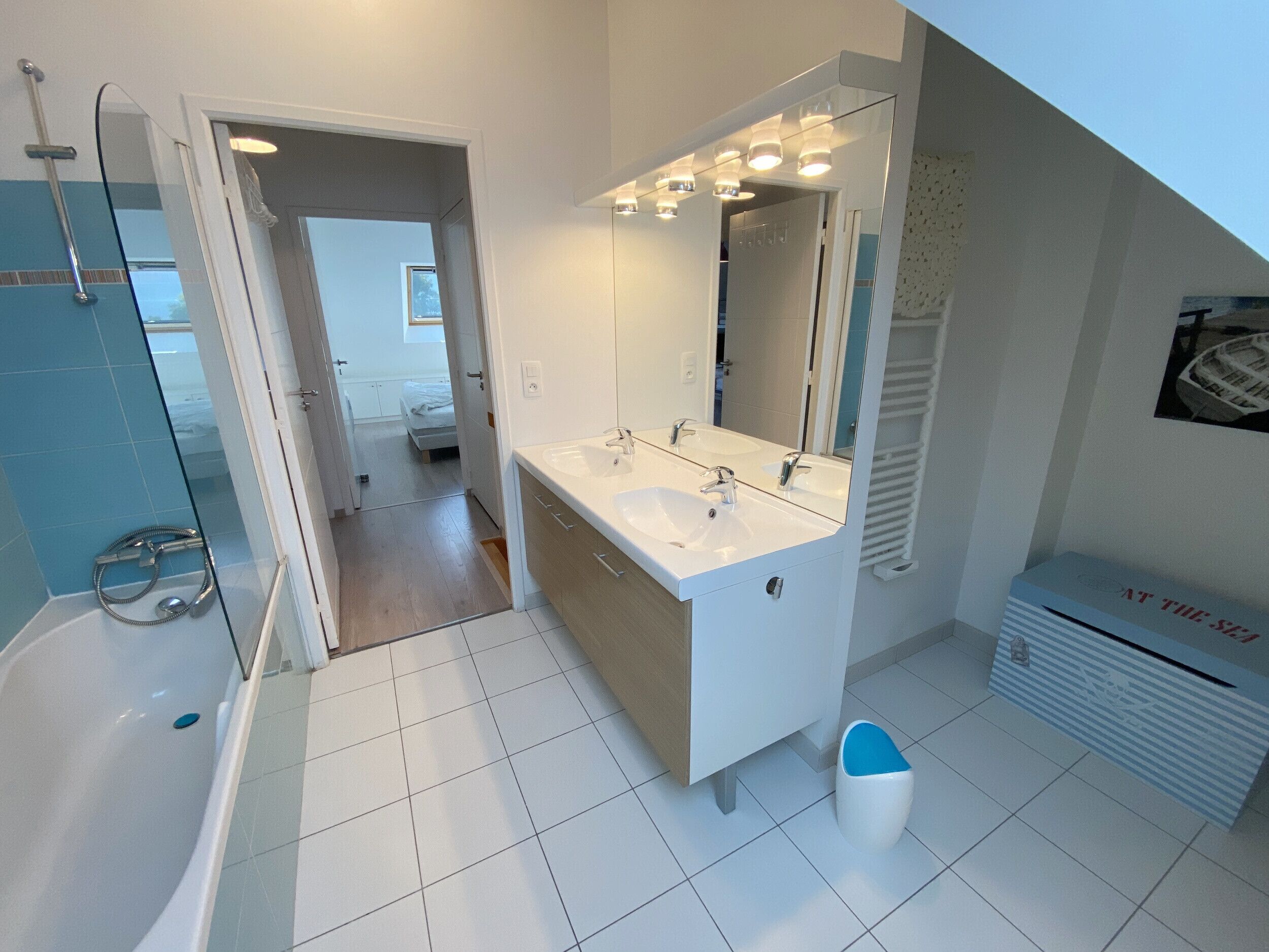 A modern bathroom with a bathtub, a double sink vanity, and a shower.