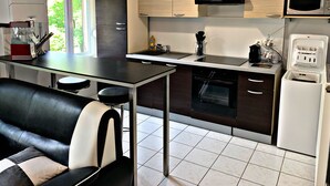 Eine moderne Küche mit Essbereich, inklusive einer Couch, einer Kaffeemaschine und einer Mikrowelle.