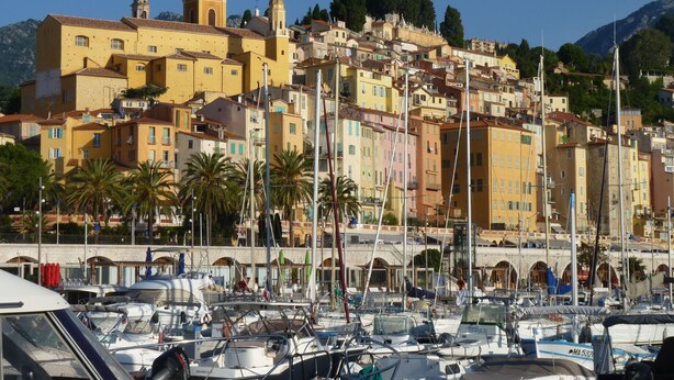 A coastal town with colorful buildings, a prominent church with a bell tower, and a marina with boats. - Studio sea view, wifi, spacious + balcony, near beach and shops (Menton)