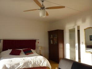 A bedroom with a bed, a ceiling fan, a wardrobe, and a mirror. - Studio sea view, wifi, spacious + balcony, near beach and shops (Menton)