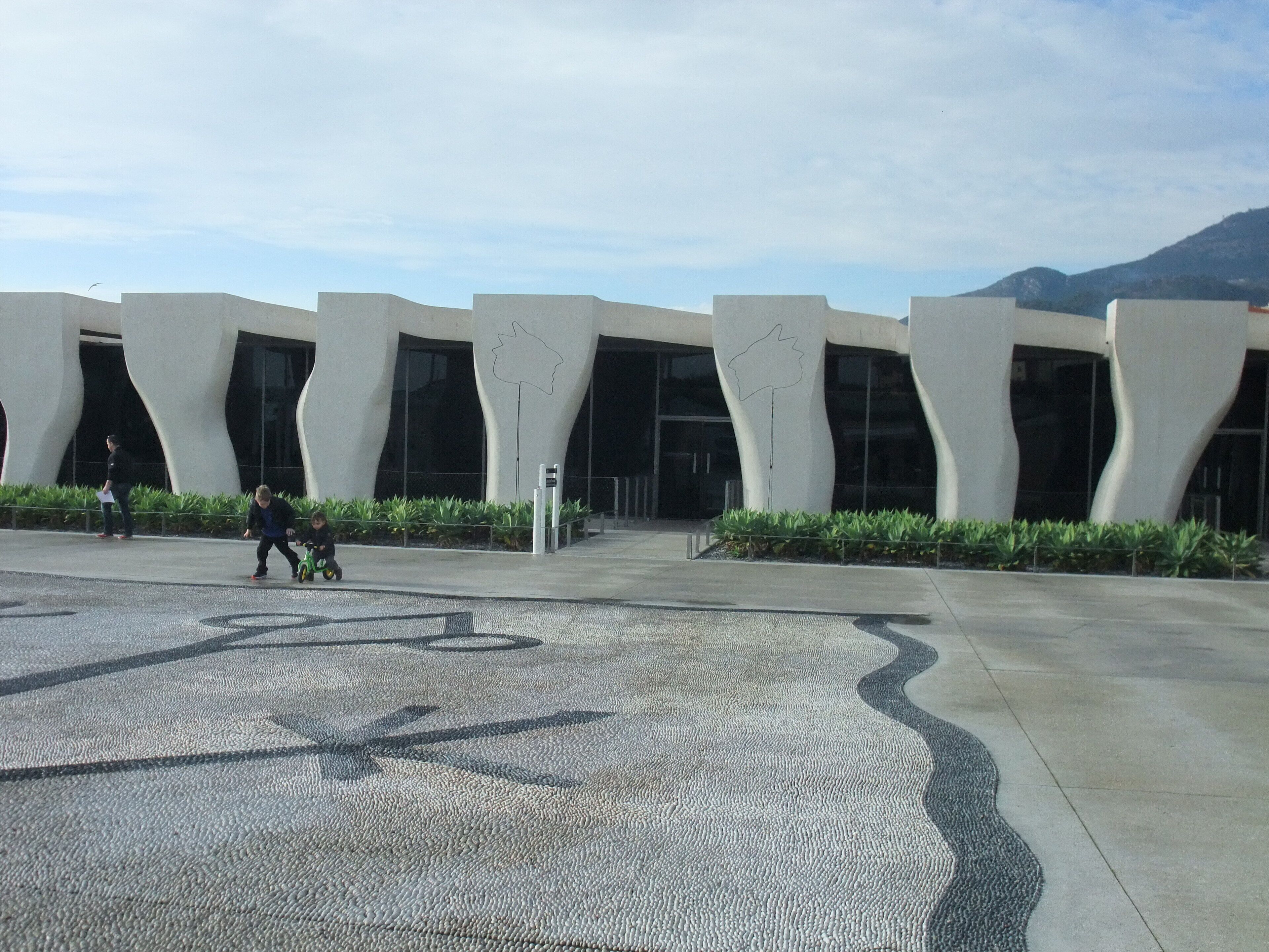 Un edificio moderno con arquitectura singular, que presenta líneas curvas y grandes ventanales.