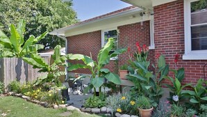 Une maison en briques avec un jardin devant.