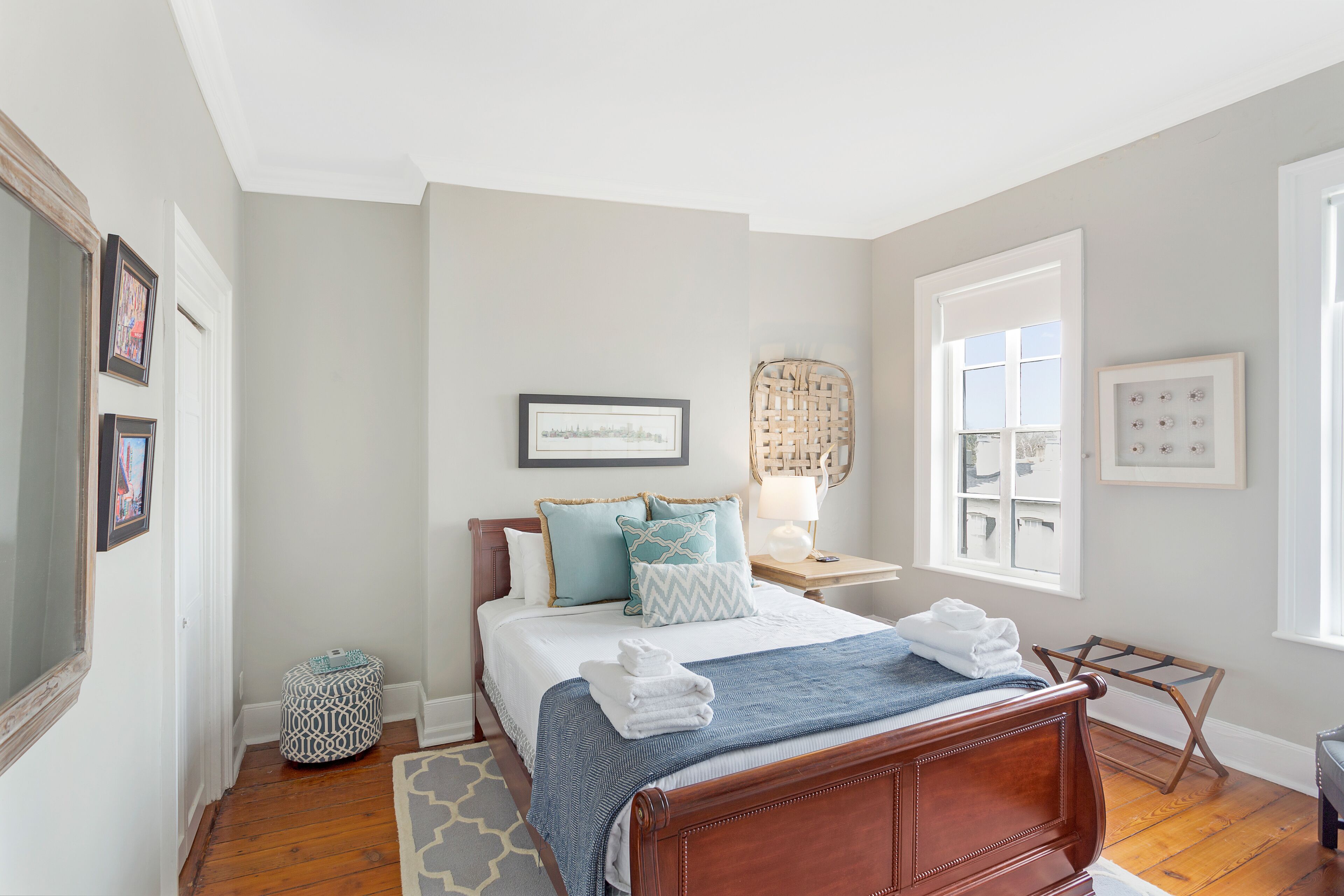 A bedroom with a wooden bed, a nightstand, a window, and a door.