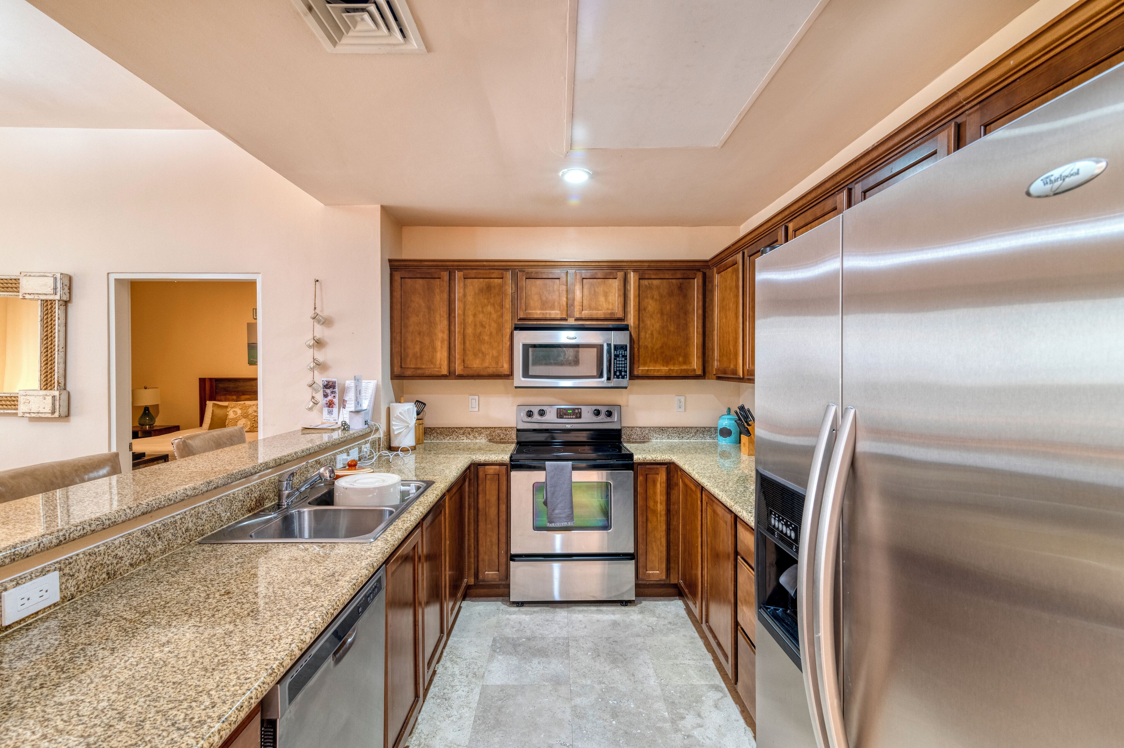 A modern kitchen with granite countertops, stainless steel appliances, and wooden cabinets.