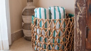 Un coin agrémenté d’un panier en osier, d’un grand vase orné de branches et d’un meuble en bois.
