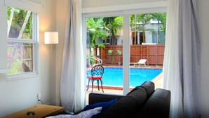 A room with a view of a swimming pool, a chair, and a table. - Close to beach, downtown, airport. Entire Apt. (Fort Lauderdale)