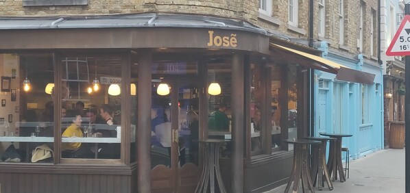 A restaurant named 'Jose' with outdoor seating and hanging lights.