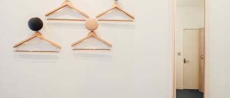 A hallway with wooden hangers and balls on the wall, leading to a door.