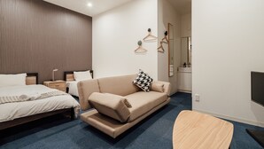 Ein modernes Hotelzimmer mit einem großen Bett, einer Couch, einem kleinen Tisch und einem Fernseher.