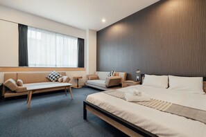A modern hotel room with a large bed, a sofa, a small table, and a nightstand. - Playsis East Tokyo (Tokyo)